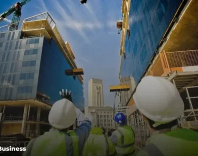 Construction workers and cranes at a building site representing a construction business