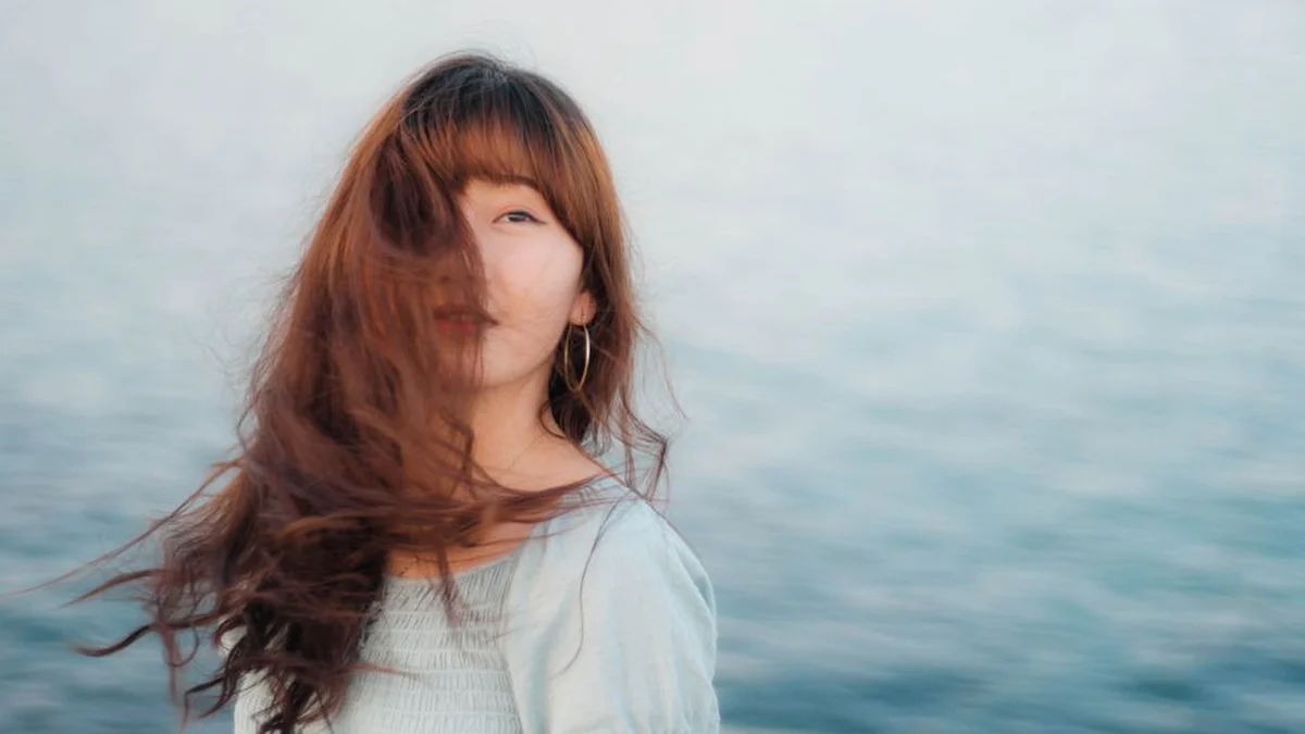 long hair blowing in the wind by the sea