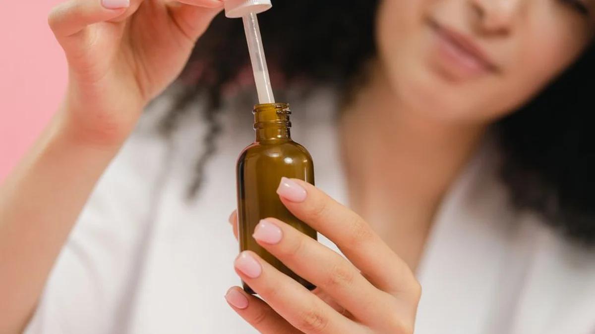 woman holding a bottle of hair serum
