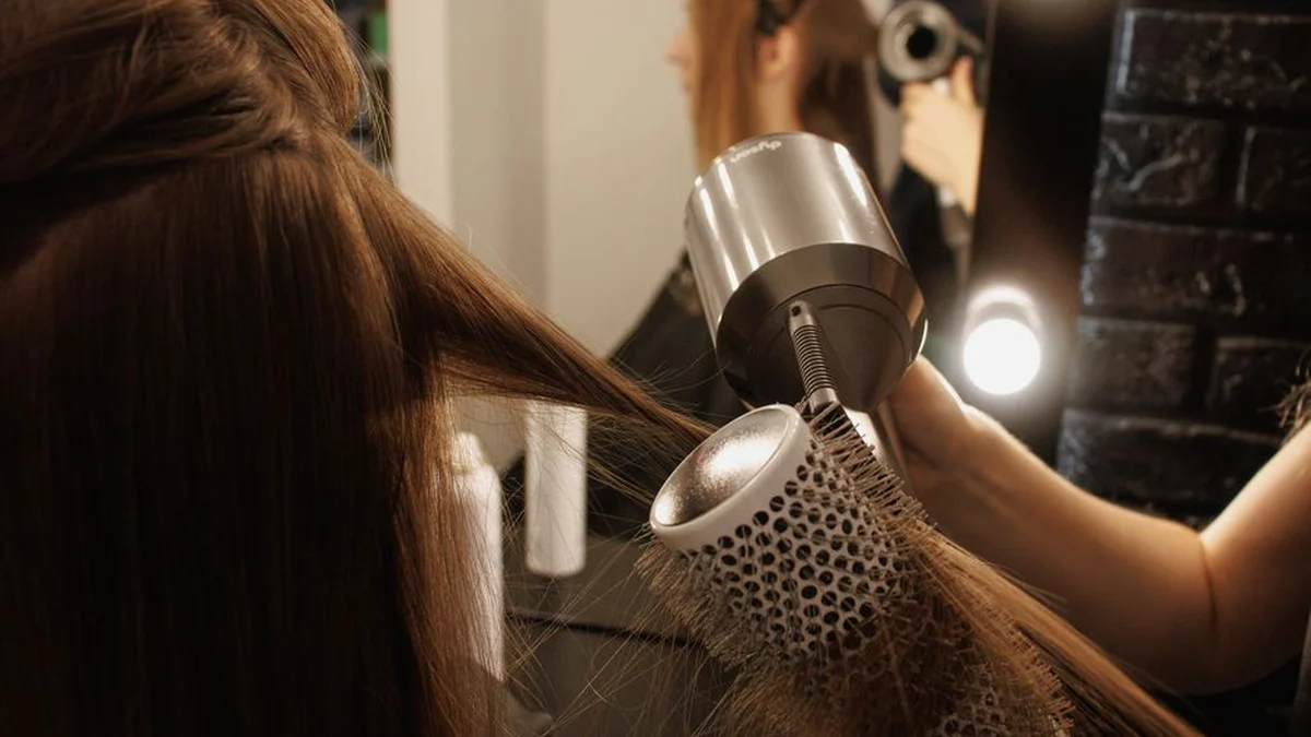 stylist blow drying a client's hair