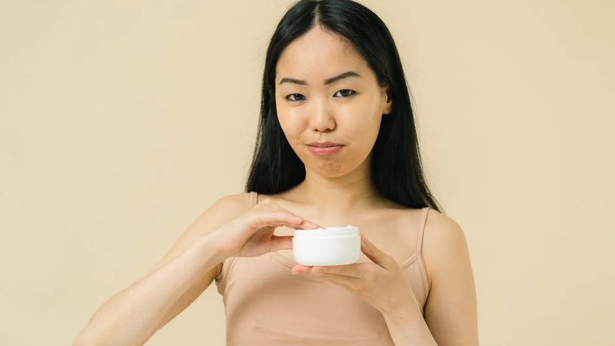 woman holding a tub of curl defining cream