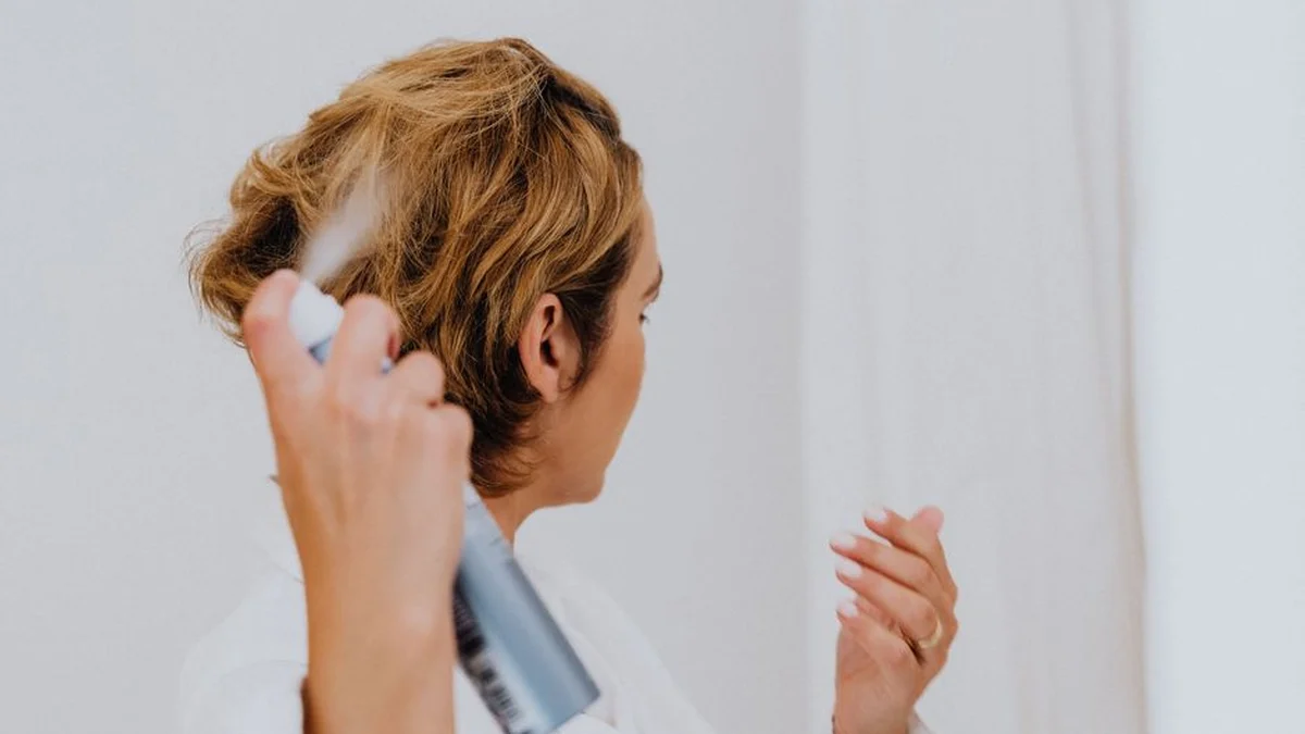 spraying the back of the head to reset flattened curls