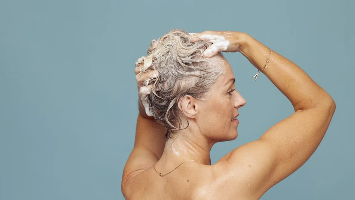 lathering shampoo into hair in the shower