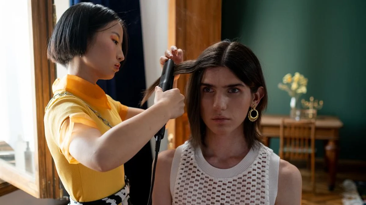stylist straightening a client's hair in a salon