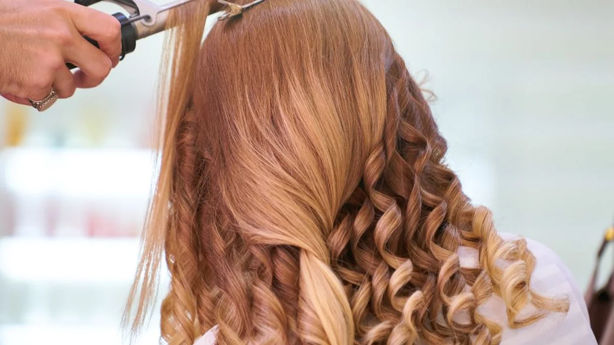curling blonde hair around a barrel
