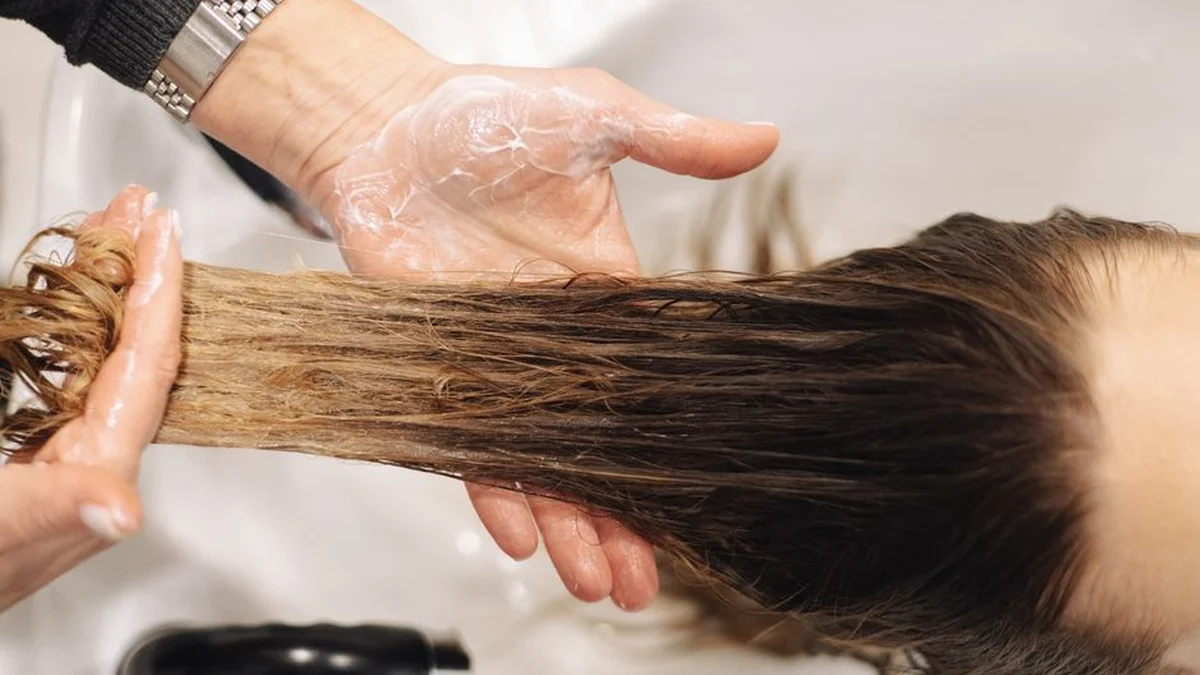 stylist smoothing a section of long hair