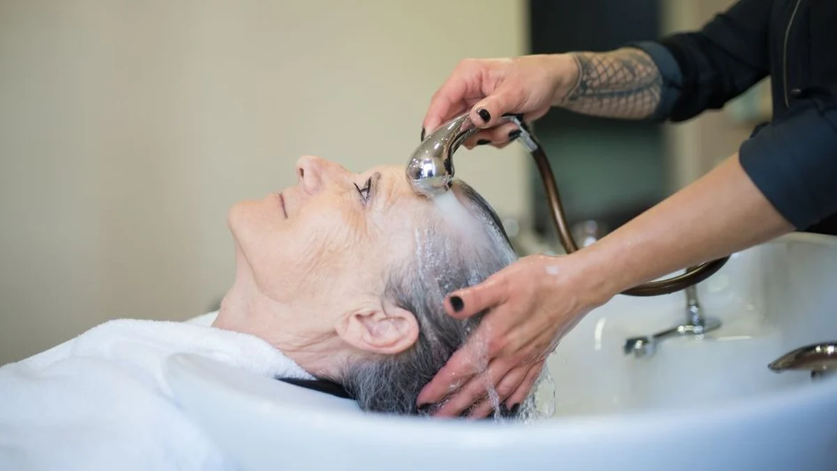 client having her hair washed at the salon basin