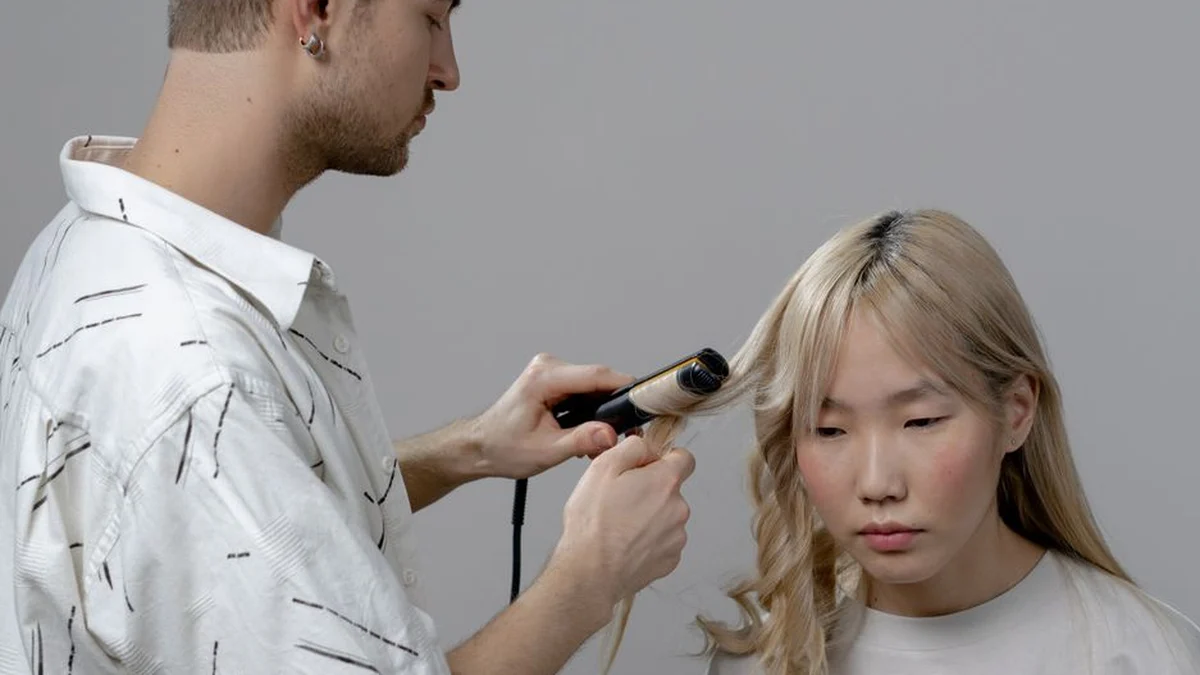 stylist sealing a section with a flat iron in a salon