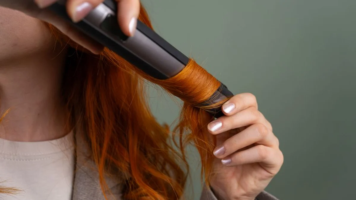 curling long red hair with a curling iron