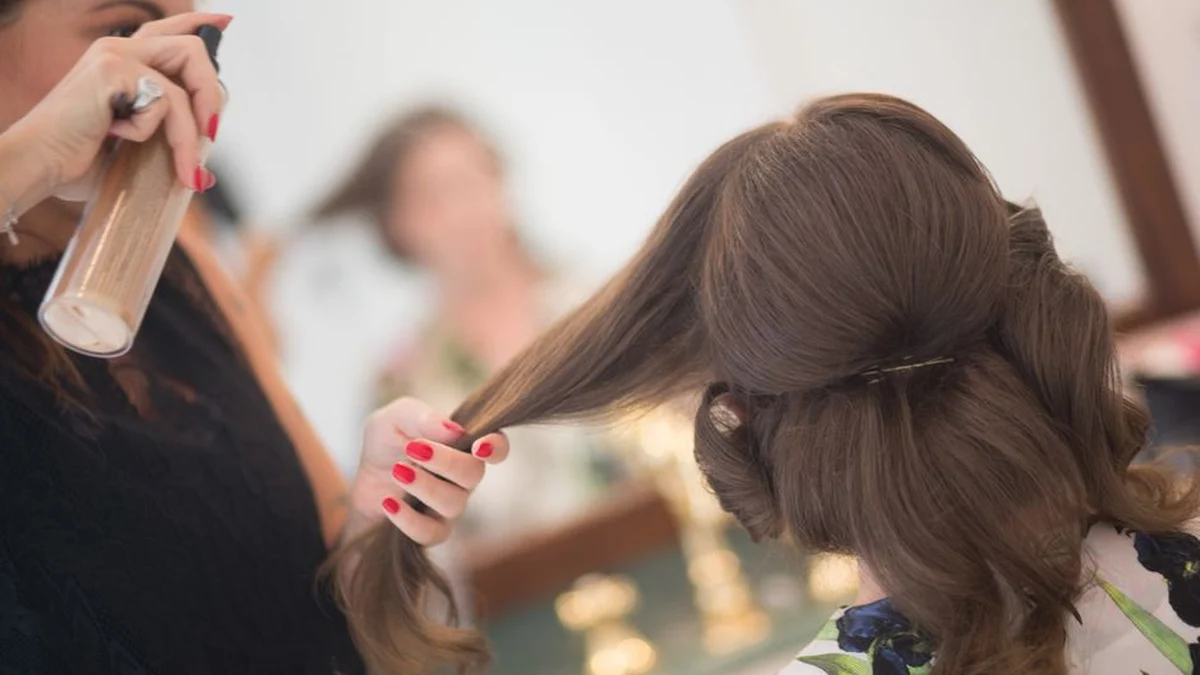 spraying long hair section by section in a salon